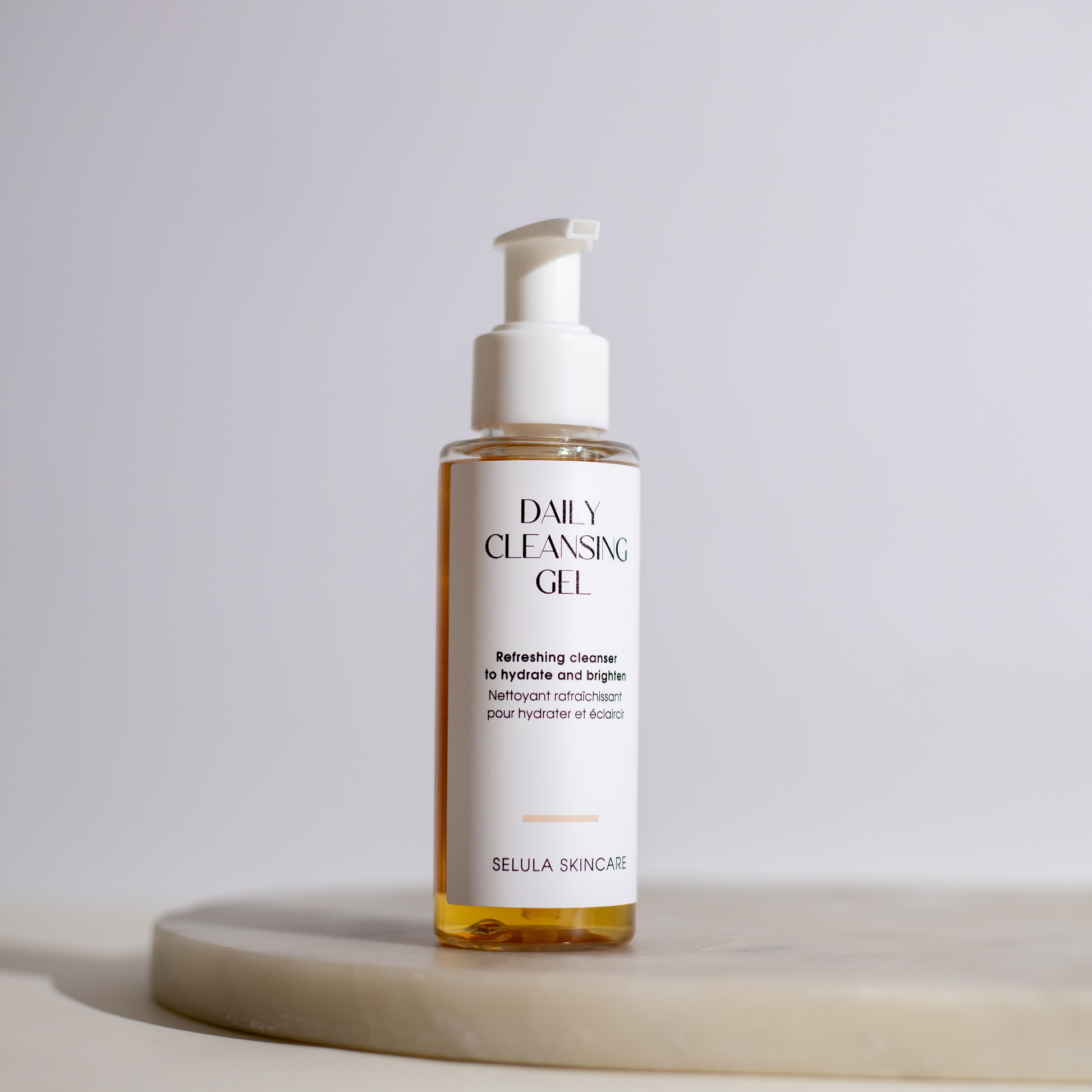 Bottle of Daily Cleansing Gel on a light surface with a neutral background