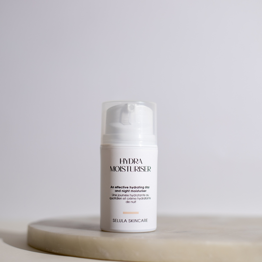 Skincare bottle labeled 'Hydra Moisturiser' on a light surface with a neutral background